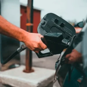 Mão de homem abastecendo carro preto