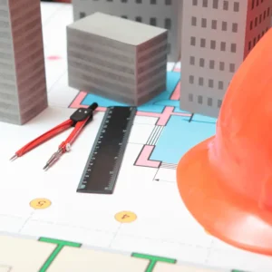 mesa com artigos de engenharia como régua, compasso e capacete de segurança