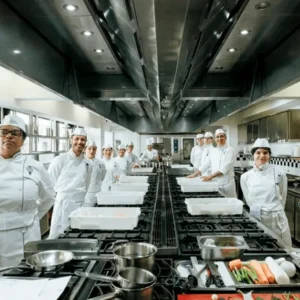 Cozinheiros formado uma fica em frente ao fogão industrial