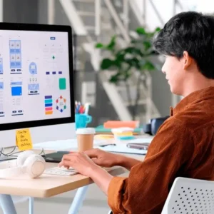 Pessoa sentada à frente do computador criando gráficos